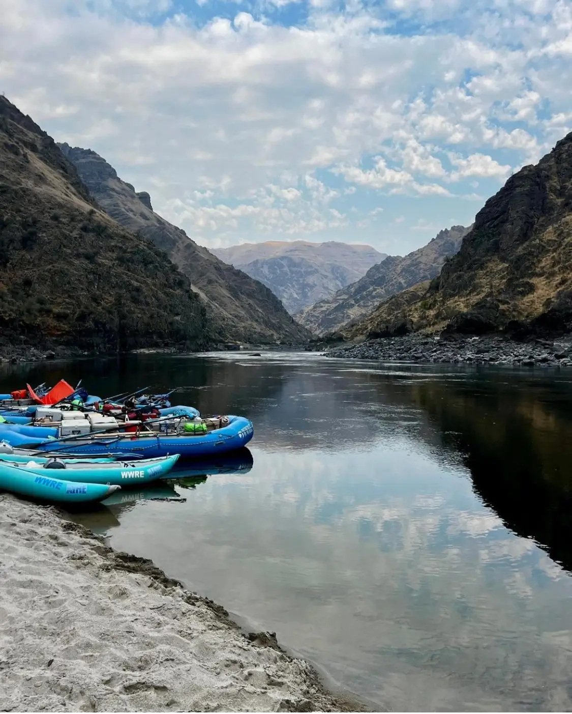 Blue rafts beached on a sandy shore in a canyon | Adventure Therapy & Resilience Building Retreats | Covington, LA (70433)